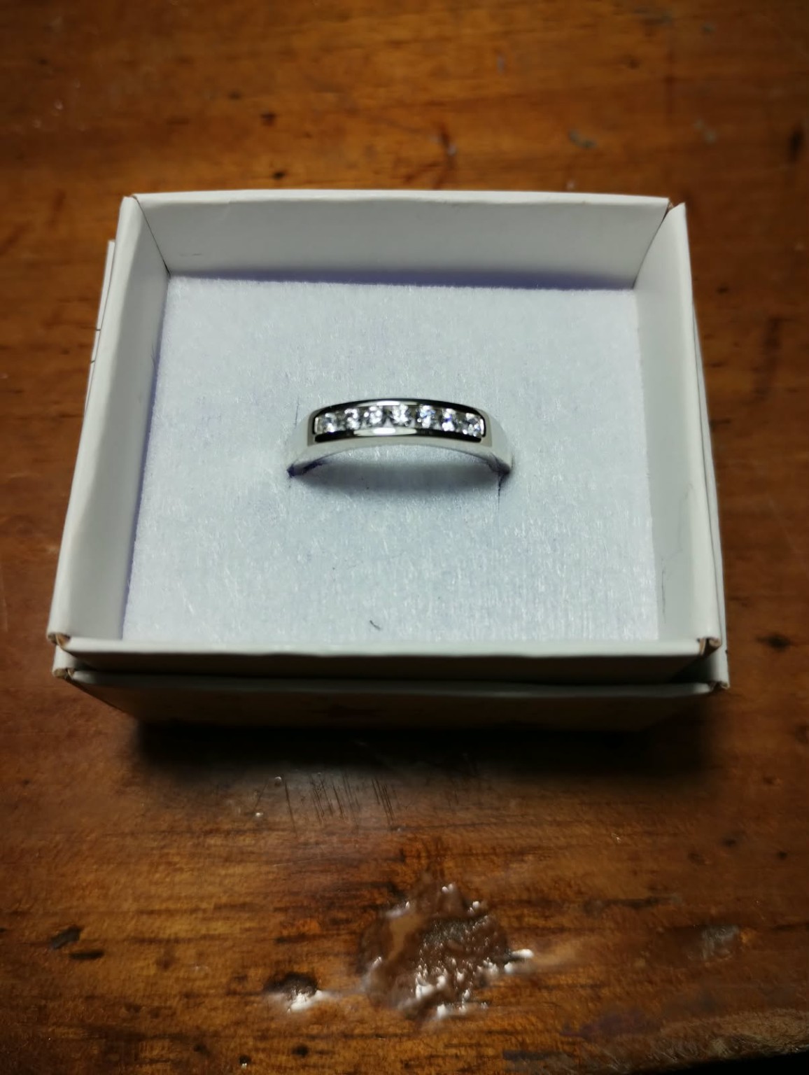 Anillo con una hilera de piedras claras en engarce de riel