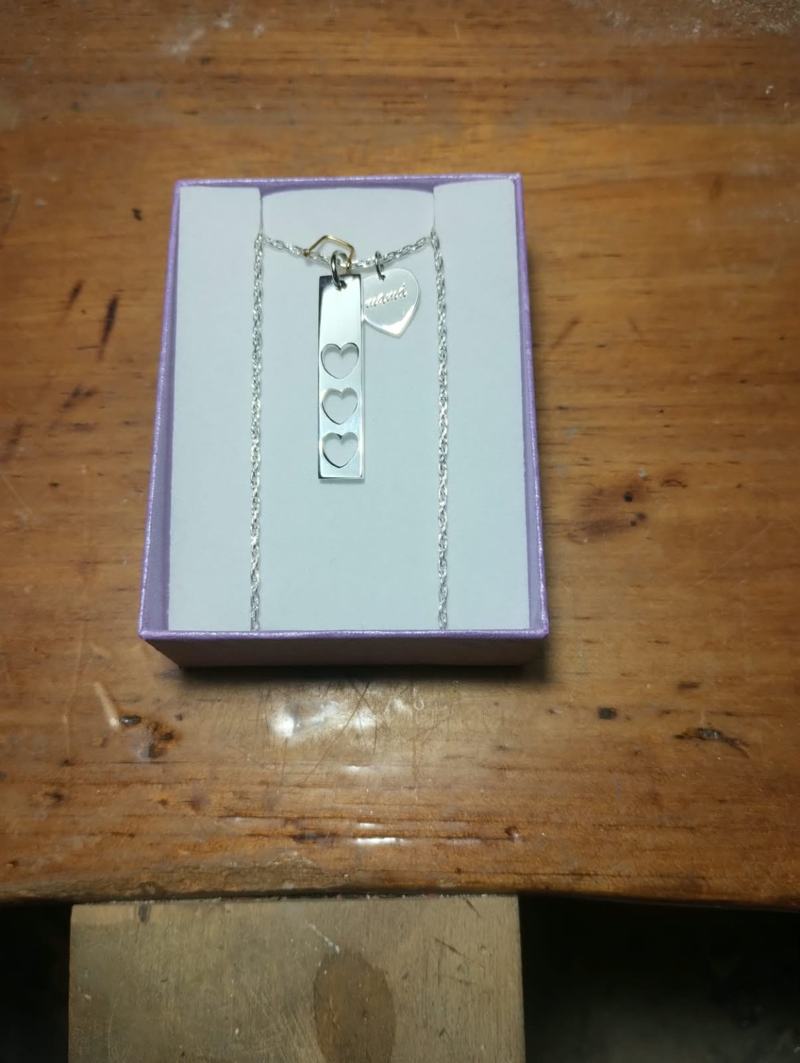 Dije rectangular con tres corazones calados junto a un corazón grabado mamá