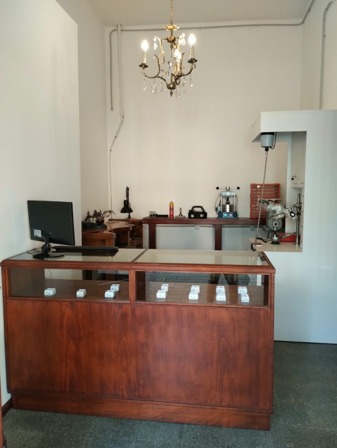 Mostrador de madera y vidrio con el espacio de trabajo de Joyas Taller al fondo