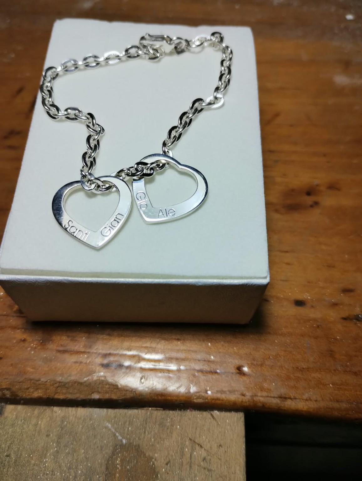 Pulsera con dos corazones calados y nombres grabados